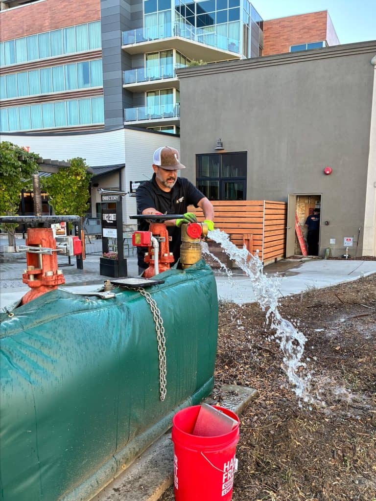 Firefighter testing fire sprinkler system at a commercial property in California.